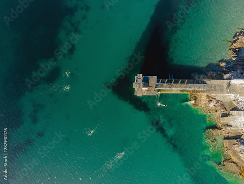 Blackrock diving tower, Salthill promenade, Galway city, Aerial top view. Sunny warm day. People are swimming in the Atlantic ocean. © mark_gusev