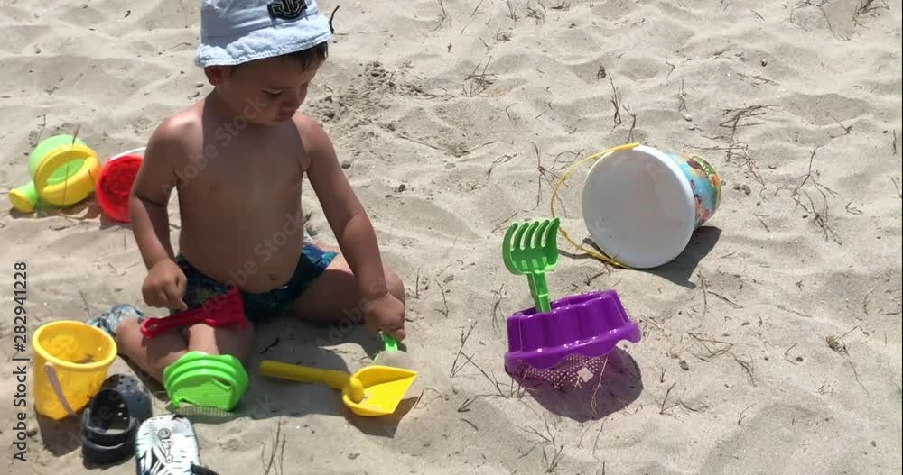 Child playing with bucket and shovel on the beach Child playing with bucket and shovel on the beach