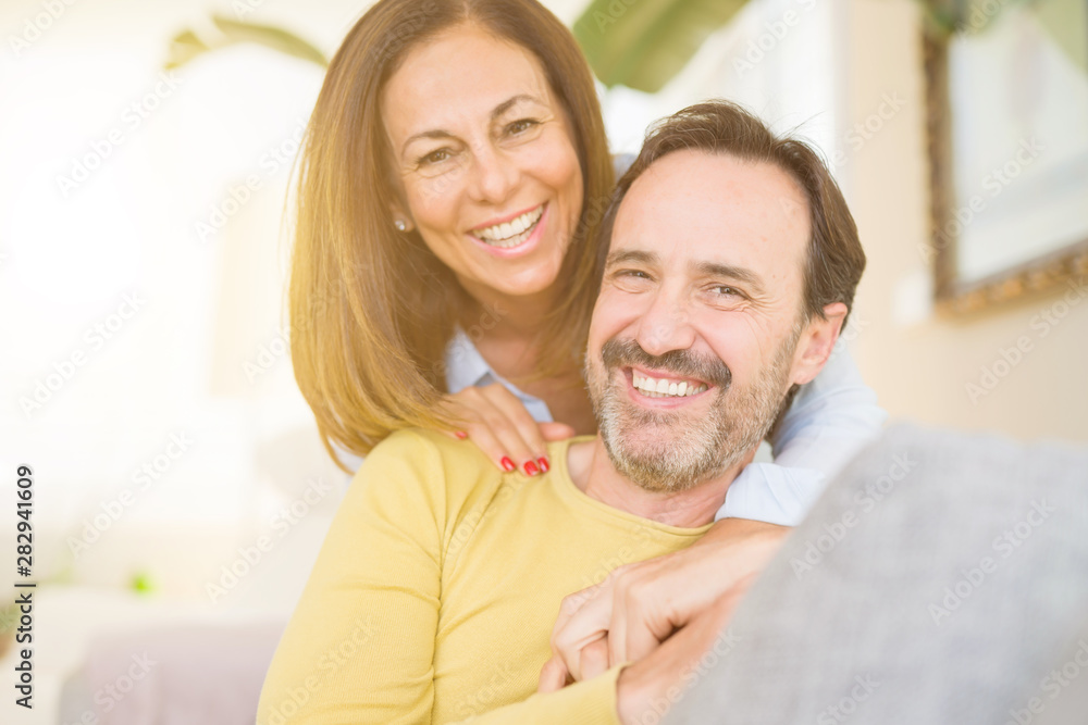Middle age romantic couple sitting on the sofa at home Middle age romantic couple sitting on the sofa at home