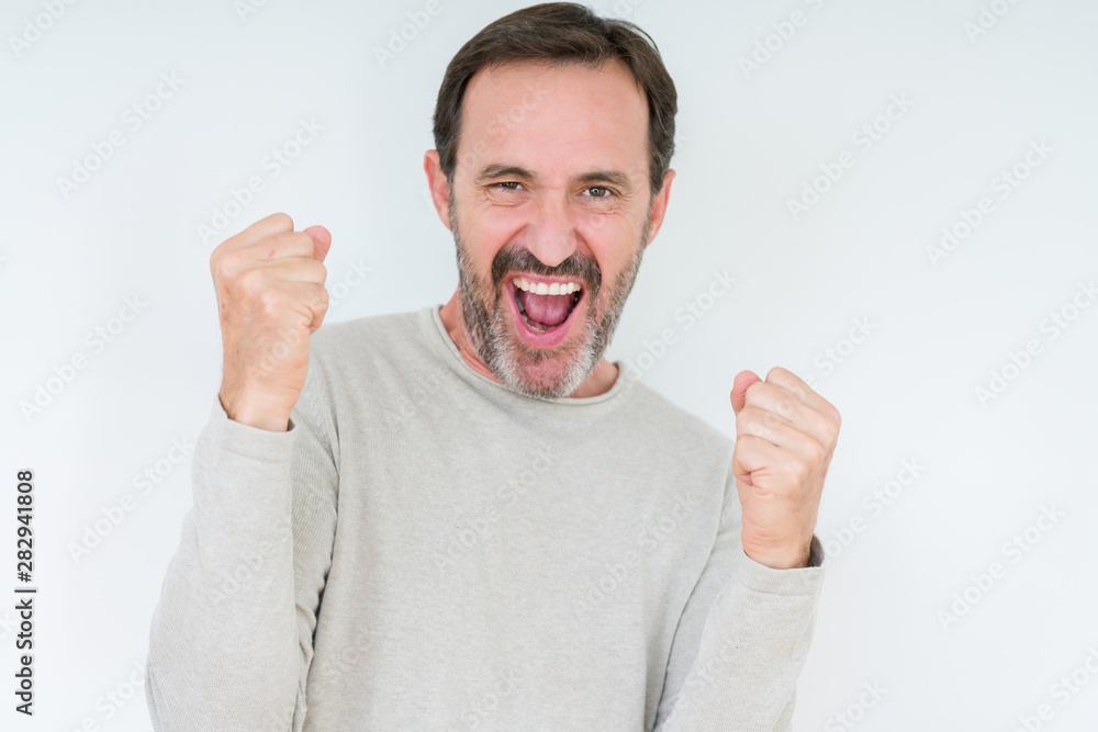 Elegant senior man over isolated background very happy and excited doing winner gesture with arms raised, smiling and screaming for success. Celebration concept. Elegant senior man over isolated background very happy and excited doing winner gesture with arms raised, smiling and screaming for success. Celebration concept.