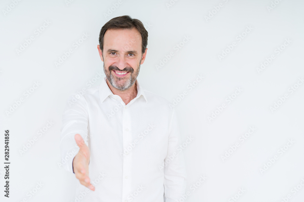 Elegant senior man over isolated background smiling friendly offering handshake as greeting and welcoming. Successful business. Elegant senior man over isolated background smiling friendly offering handshake as greeting and welcoming. Successful business.