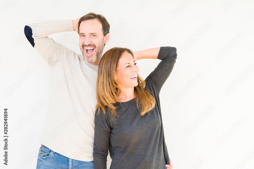 Beautiful middle age couple in love over isolated background Smiling confident touching hair with hand up gesture, posing attractive Beautiful middle age couple in love over isolated background Smiling confident touching hair with hand up gesture, posing attractive