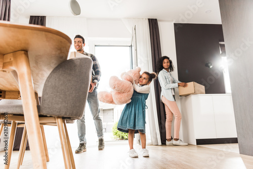 low angle view of african american family walking into house while holding different stuff