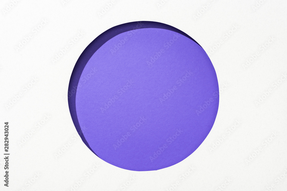 cut out round hole in white paper on violet colorful background cut out round hole in white paper on violet colorful background