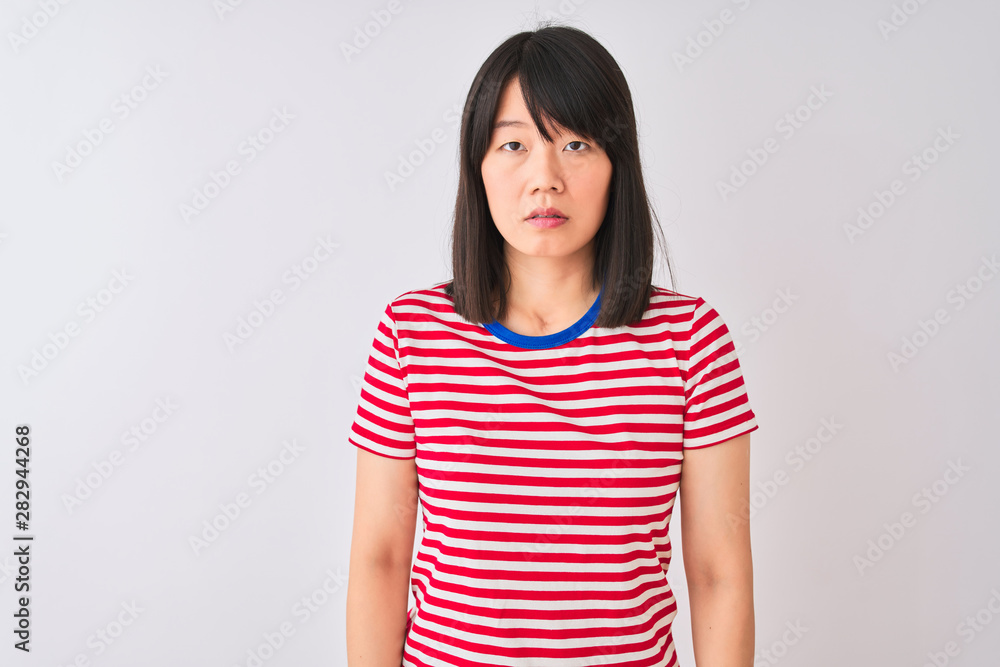 Young beautiful chinese woman wearing red striped t-shirt over isolated white background Relaxed with serious expression on face. Simple and natural looking at the camera. Young beautiful chinese woman wearing red striped t-shirt over isolated white background Relaxed with serious expression on face. Simple and natural looking at the camera.