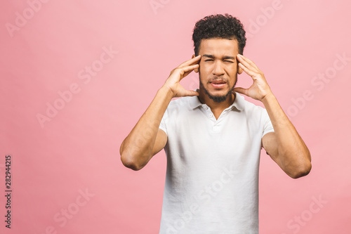 Young dark-skinned hipster guy holding hands on head looking desperately down going to cry while found out about something horrorful. Crying man with bushy hair having troubles. photo