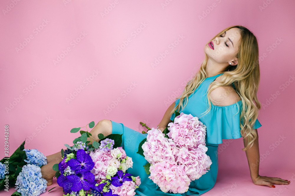 Wonderful and pertty woman holding bouquet. Female florist create a bouquet. Making beautiful flower bouquets and floral decorations. Young woman with flowers on the isolated background.