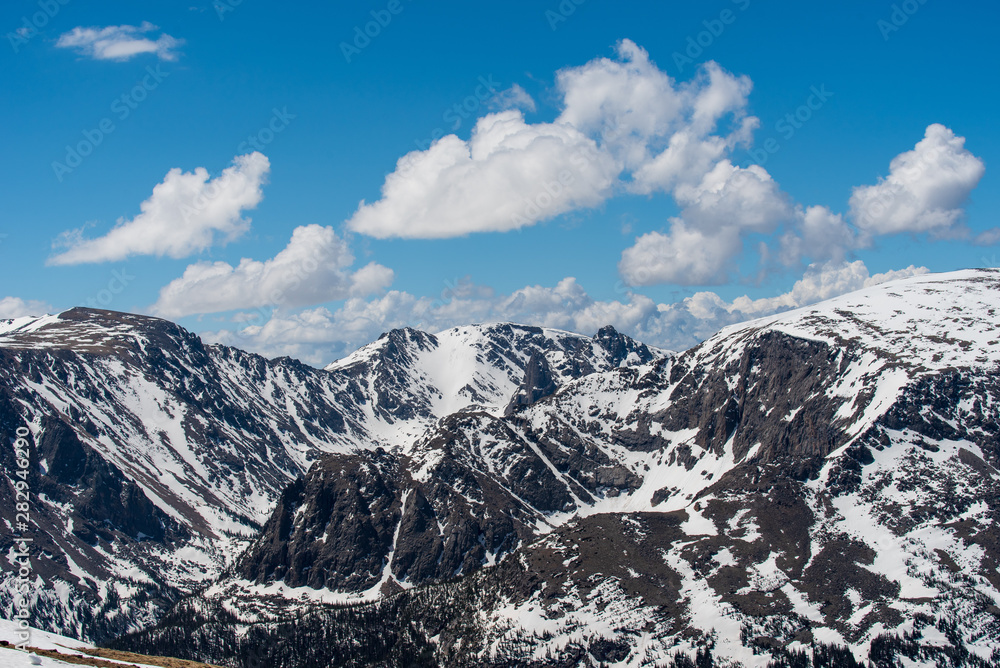 Rocky Mountain National Park low angle landscape of snow-covered mountain peaks and some clouds on a sunny day