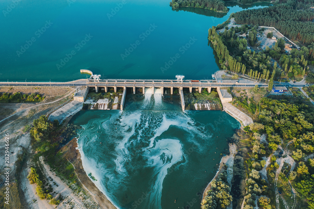 Aerial panoramic view of concrete Dam at reservoir with flowing water, hydroelectricity power station