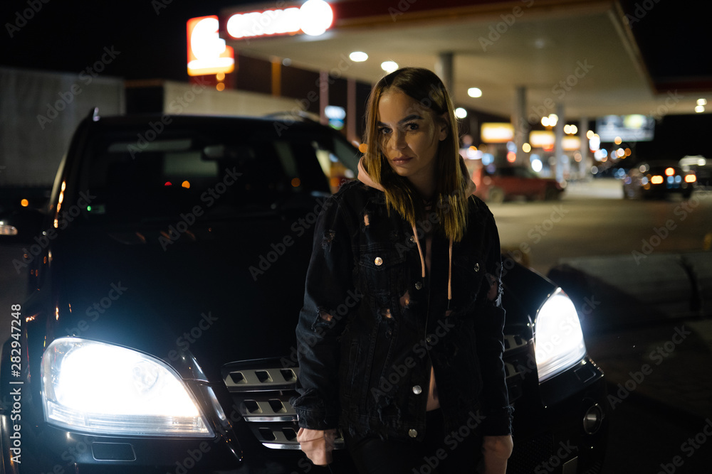 Blonde woman portrait standing at night in front of expensive car - Luxury and Fashion Blonde woman portrait standing at night in front of expensive car - Luxury and Fashion