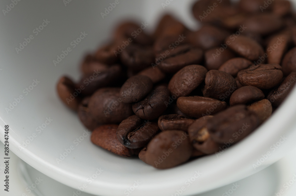 White cup of coffee and coffee beans isolated on black background White cup of coffee and coffee beans isolated on black background