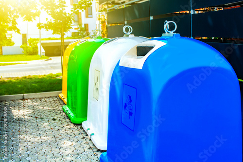 Colored plastic trash cans . Large wheelie bins . Urban recycling waste and garbage services