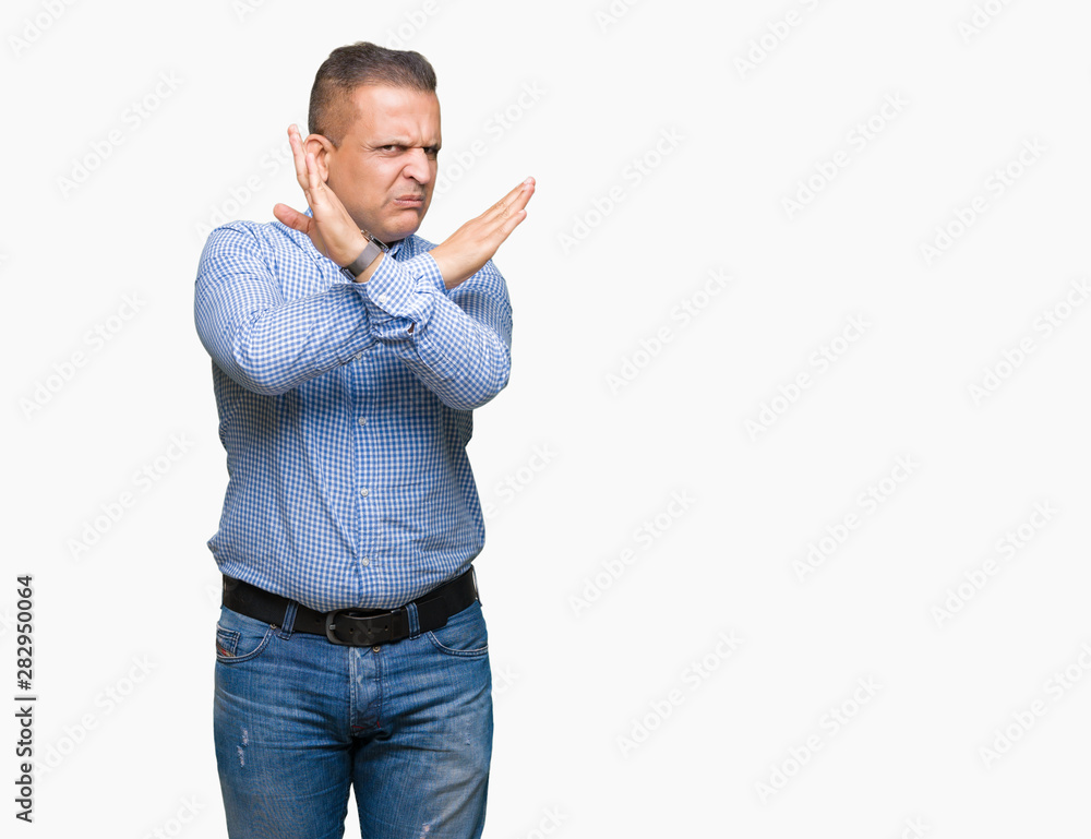 Middle age arab business man over isolated background Rejection expression crossing arms doing negative sign, angry face Middle age arab business man over isolated background Rejection expression crossing arms doing negative sign, angry face