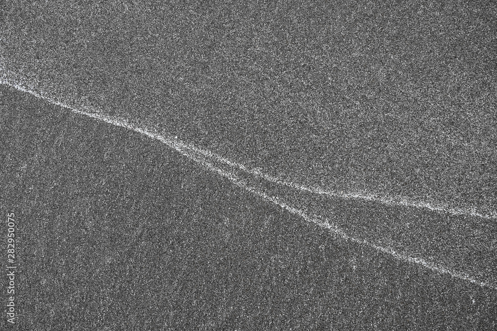 Patterns on sand, white lines left by waves on the beach.