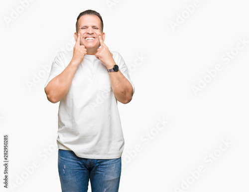 Middle age arab man wearig white t-shirt over isolated background Smiling with open mouth, fingers pointing and forcing cheerful smile