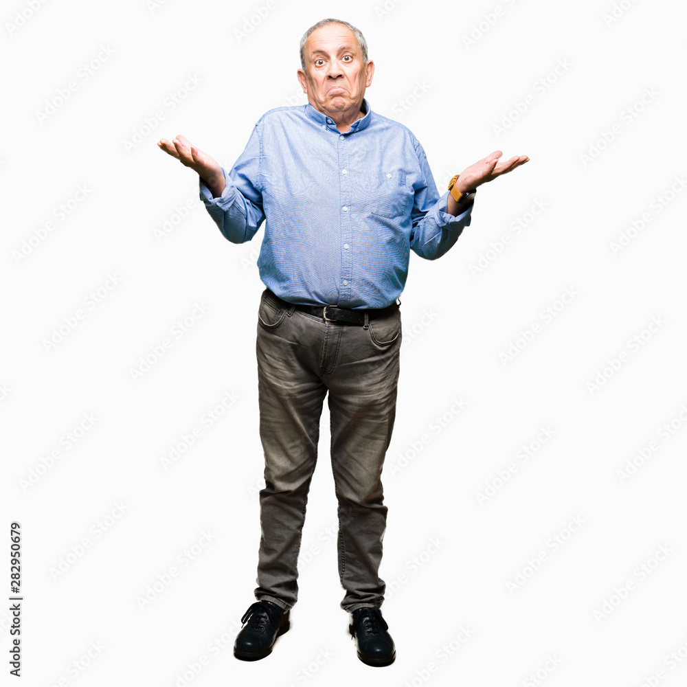 Handsome senior businesss man wearing elegant shirt clueless and confused expression with arms and hands raised. Doubt concept. Handsome senior businesss man wearing elegant shirt clueless and confused expression with arms and hands raised. Doubt concept.