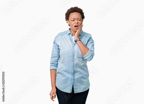 Young beautiful african american woman over isolated background touching mouth with hand with painful expression because of toothache or dental illness on teeth. Dentist concept.