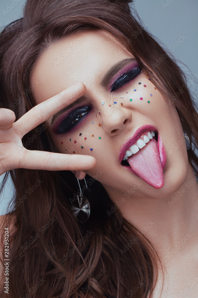 Of Female Model With Creative Makeup. image of great beauty art make-up. Girl shows tongue and sign Victory. Sexy Full Lips. Beauty. Cosmetics and Skincare concept Stock Photo | Adobe