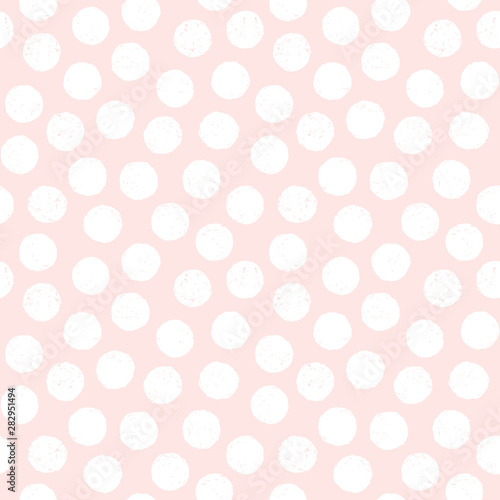 Seamless pastel background with polka dots in blush pink and white. Cute minimal pattern with textured overlay for baby, girls, gift wrapping paper, textiles, wallpaper.