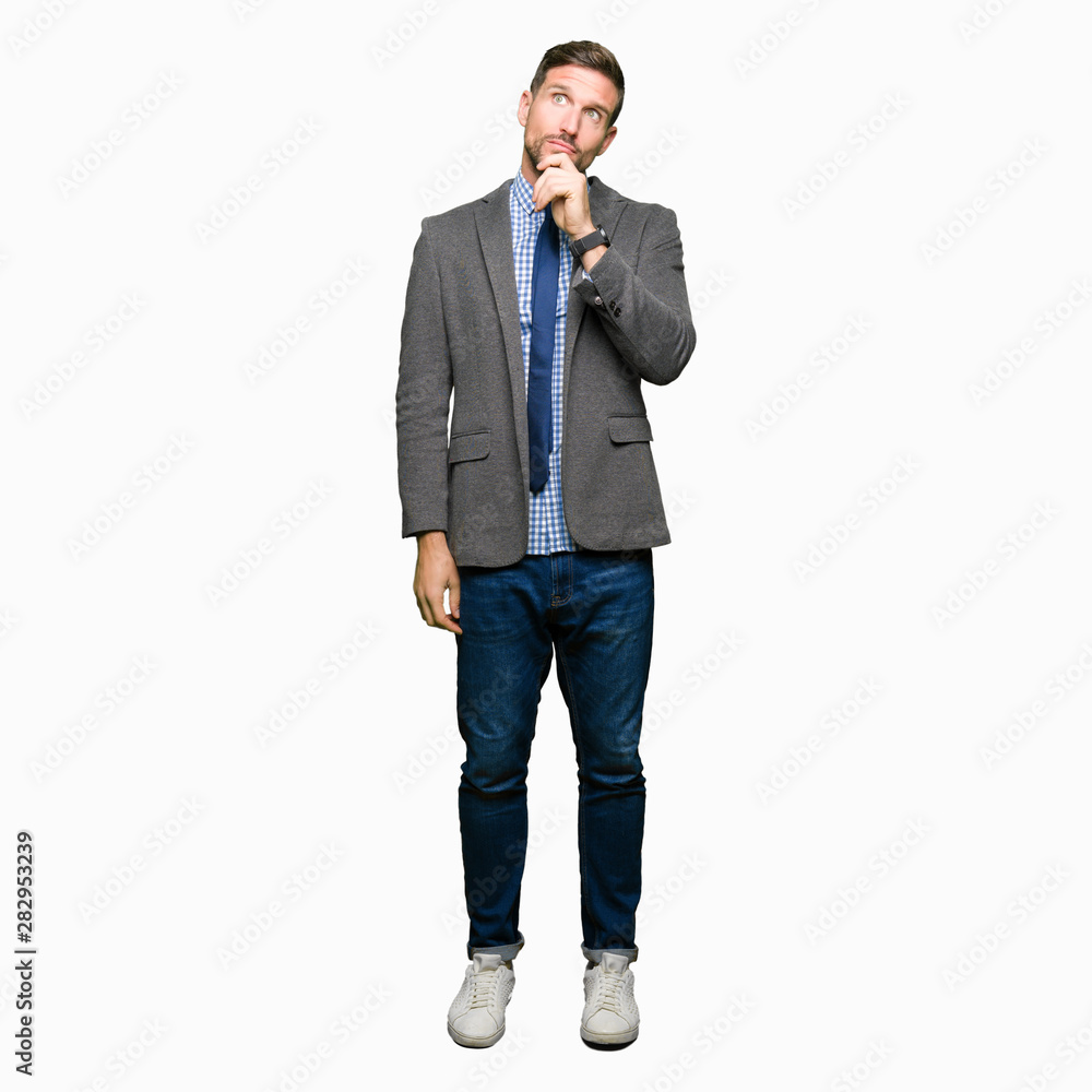Handsome business man wearing suit and tie with hand on chin thinking about question, pensive expression. Smiling with thoughtful face. Doubt concept. Handsome business man wearing suit and tie with hand on chin thinking about question, pensive expression. Smiling with thoughtful face. Doubt concept.