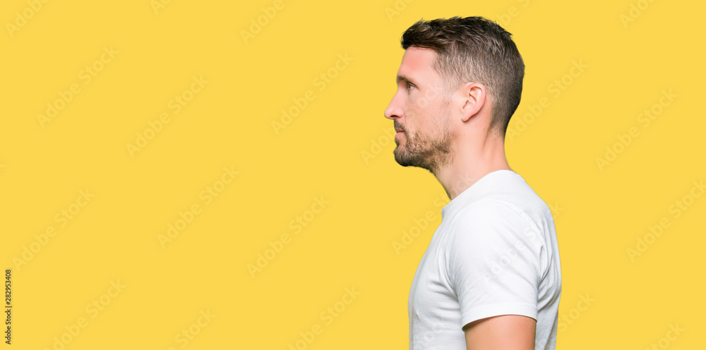 Handsome man wearing casual white t-shirt looking to side, relax profile pose with natural face with confident smile. Handsome man wearing casual white t-shirt looking to side, relax profile pose with natural face with confident smile.