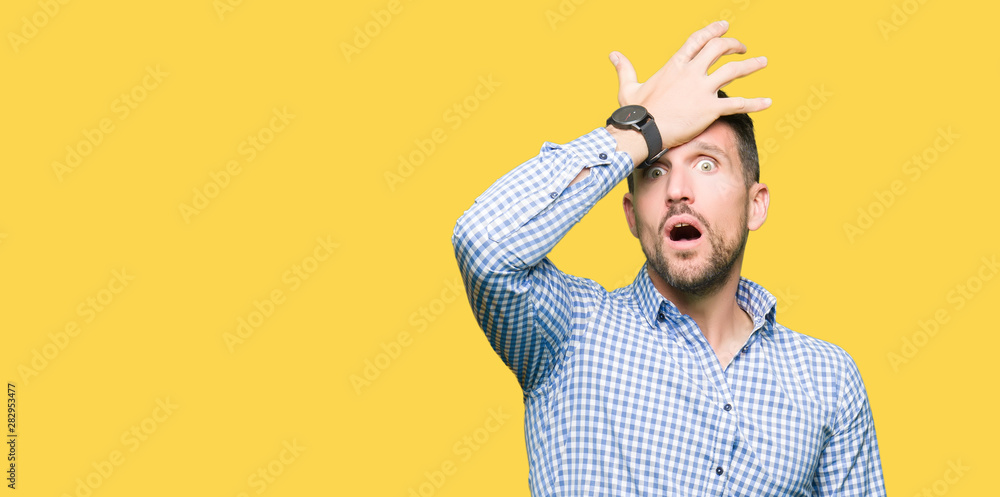 Handsome business man with blue eyes surprised with hand on head for mistake, remember error. Forgot, bad memory concept. - obrazy, fototapety, plakaty 