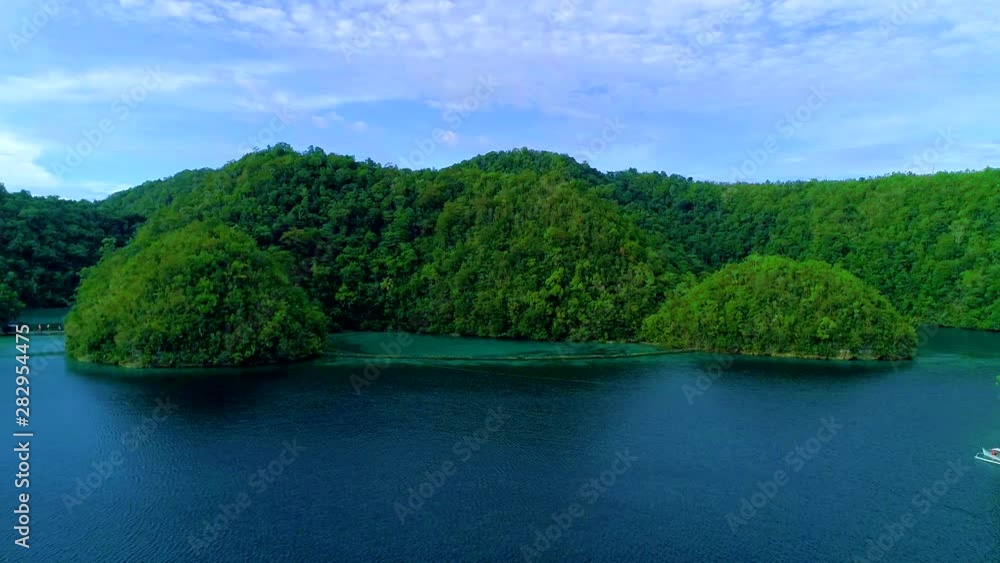 Tropical landscape rainforest hills and azure water in lagoon with clouds on the Siargao island, Philippines. Drone Aerial view 4Kl