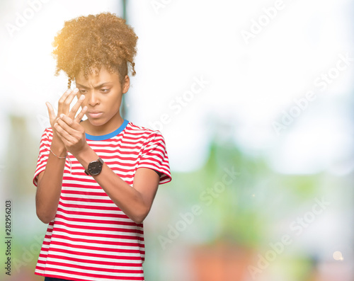 Beautiful young african american woman over isolated background Suffering pain on hands and fingers, arthritis inflammation © Krakenimages.com