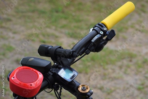 black metal bicycle wheel with a yellow handle and flashlights