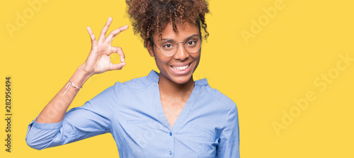 Beautiful young african american business woman over isolated background smiling positive doing ok sign with hand and fingers. Successful expression.