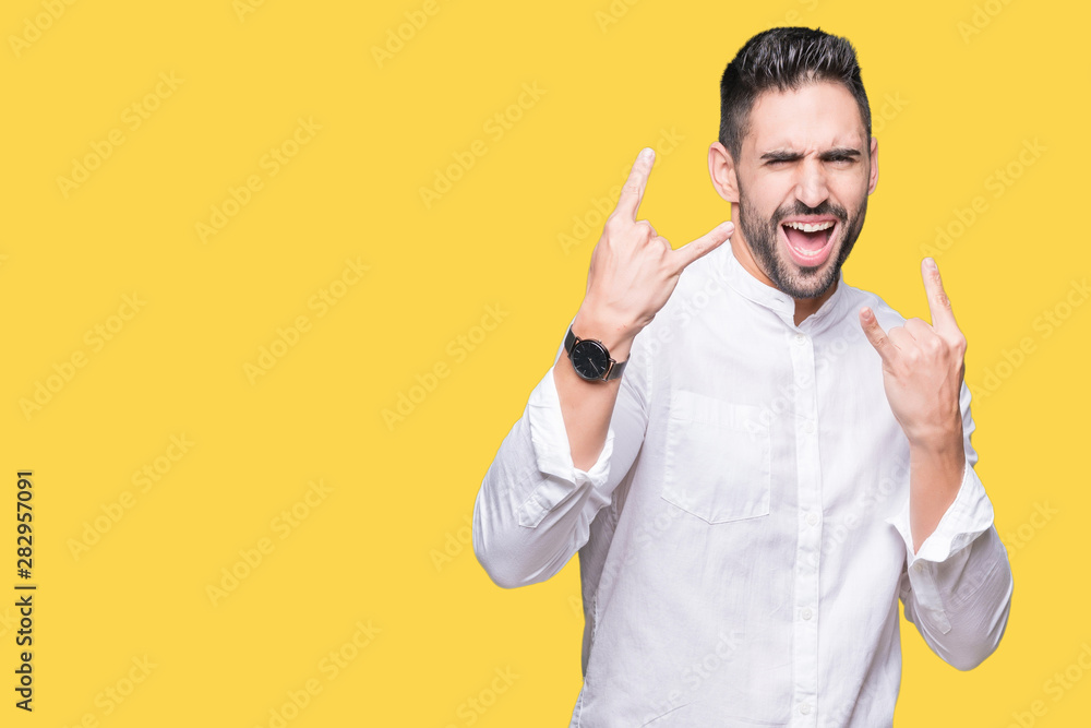 Young business man over isolated background shouting with crazy expression doing rock symbol with hands up. Music star. Heavy concept. Young business man over isolated background shouting with crazy expression doing rock symbol with hands up. Music star. Heavy concept.