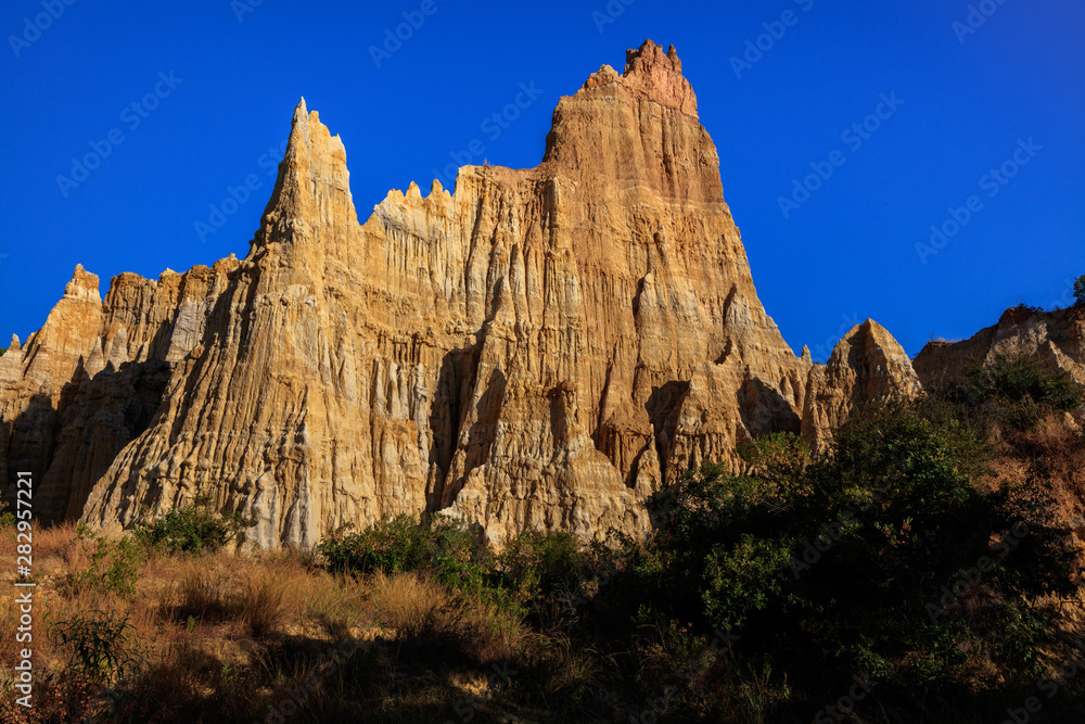 Earth Forest of Yuanmou in Yunnan Province, China - Exotic earth and sandstone formations glowing in the sunlight. Naturally formed pillars of rock and clay with unique erosion patterns. China Travel