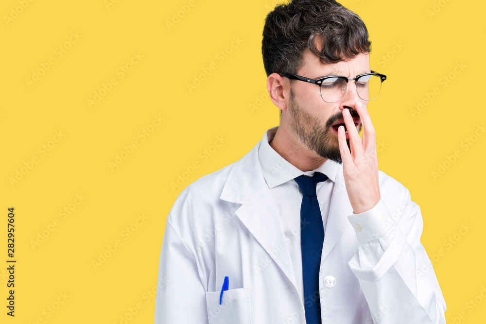 Young professional scientist man wearing white coat over isolated background bored yawning tired covering mouth with hand. Restless and sleepiness. Young professional scientist man wearing white coat over isolated background bored yawning tired covering mouth with hand. Restless and sleepiness.