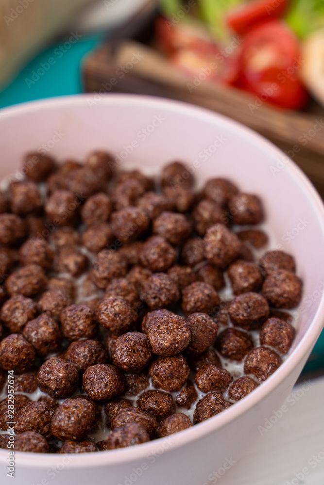 Close up of full bowl of crunchy chocolate balls with milk Close up of full bowl of crunchy chocolate balls with milk
