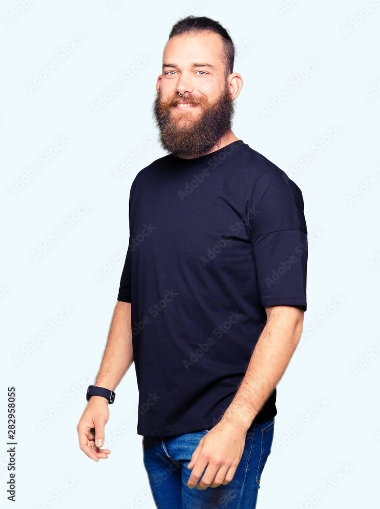 Fototapeta premium Young blond man wearing casual t-shirt looking away to side with smile on face, natural expression. Laughing confident.