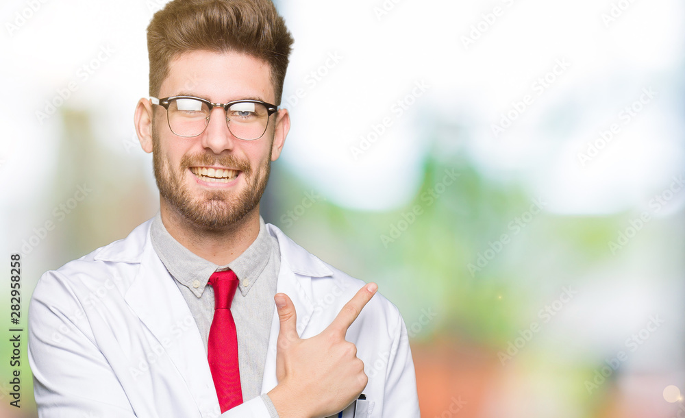 Young handsome scientist man wearing glasses cheerful with a smile of face pointing with hand and finger up to the side with happy and natural expression on face Young handsome scientist man wearing glasses cheerful with a smile of face pointing with hand and finger up to the side with happy and natural expression on face
