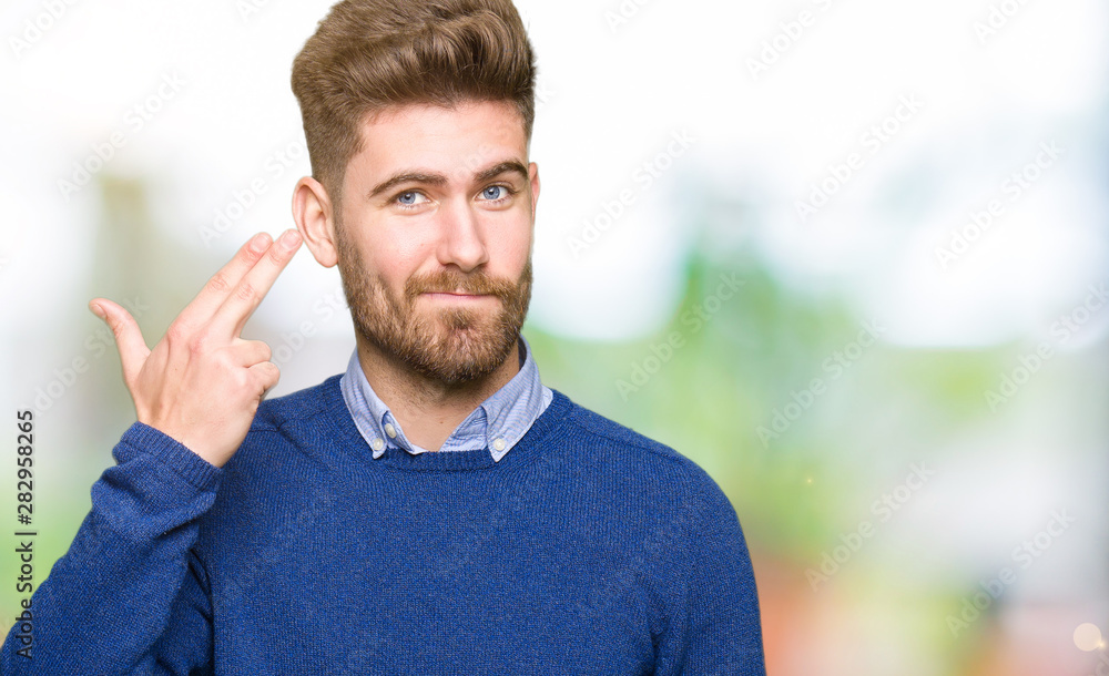 Young handsome bussines man Shooting and killing oneself pointing hand and fingers to head, suicide gesture. Young handsome bussines man Shooting and killing oneself pointing hand and fingers to head, suicide gesture.