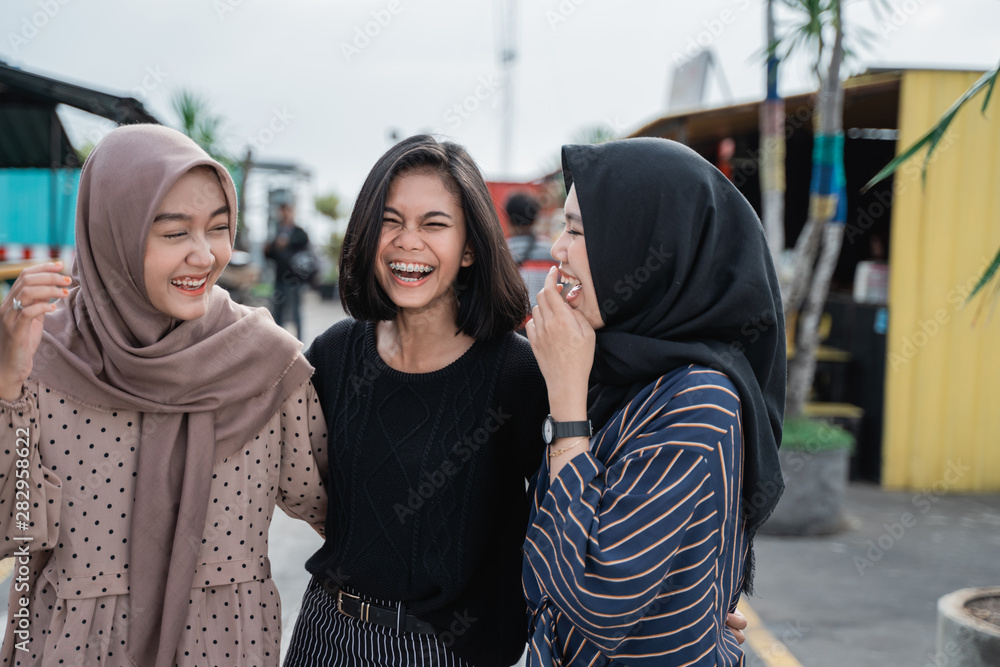 three happy young people laughing together three happy young people laughing together
