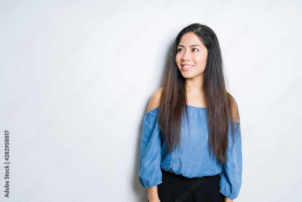 Beautiful brunette woman over isolated background looking away to side with smile on face, natural expression. Laughing confident. Beautiful brunette woman over isolated background looking away to side with smile on face, natural expression. Laughing confident.