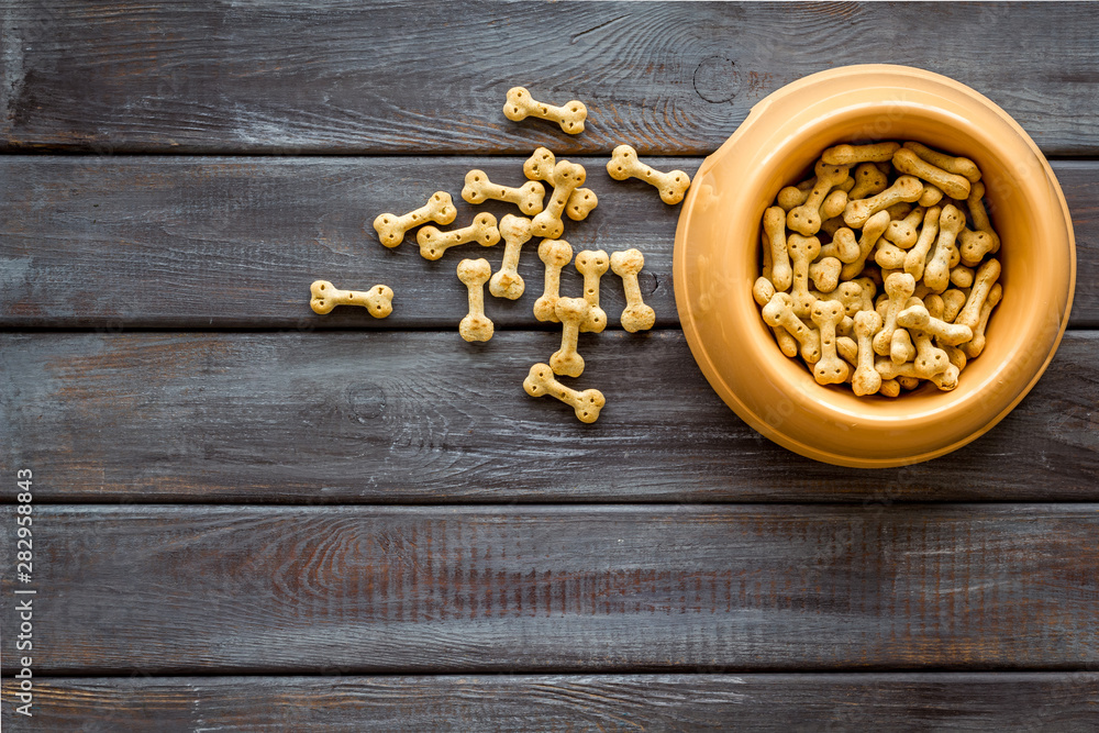 Dog dry food in bowl on wooden background top view mock-up Dog dry food in bowl on wooden background top view mock-up