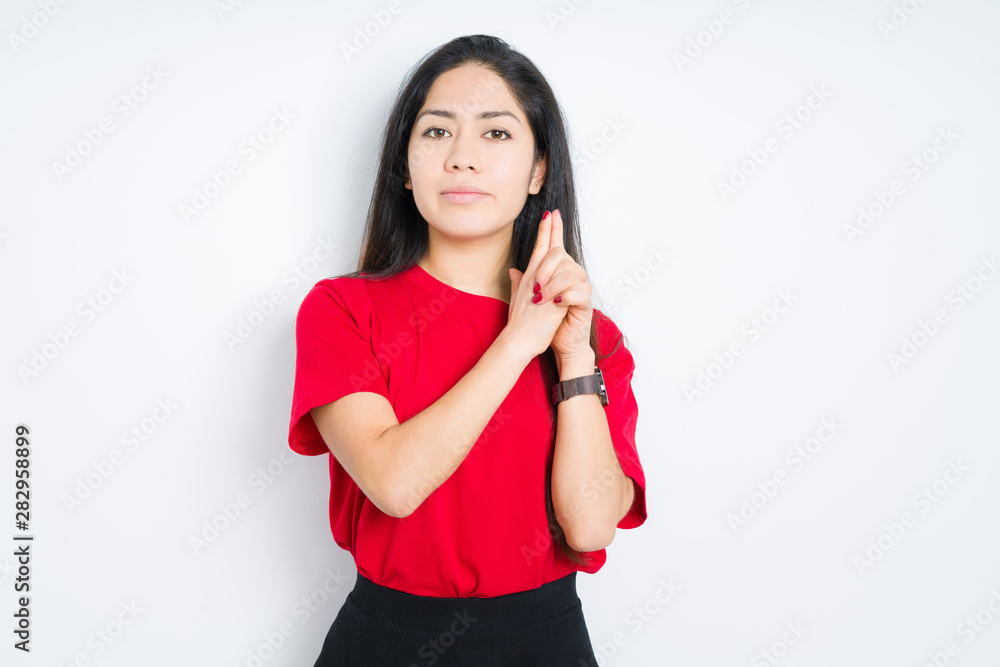 Beautiful brunette woman wearing red t-shirt over isolated background Holding symbolic gun with hand gesture, playing killing shooting weapons, angry face Beautiful brunette woman wearing red t-shirt over isolated background Holding symbolic gun with hand gesture, playing killing shooting weapons, angry face