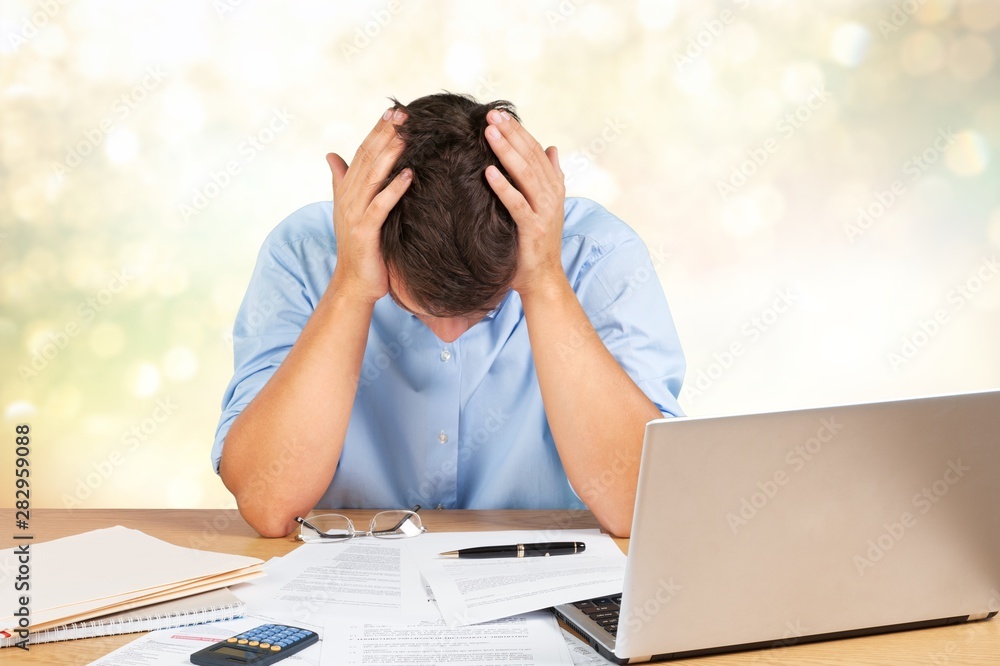 Tired young businessman with stack of papers Tired young businessman with stack of papers