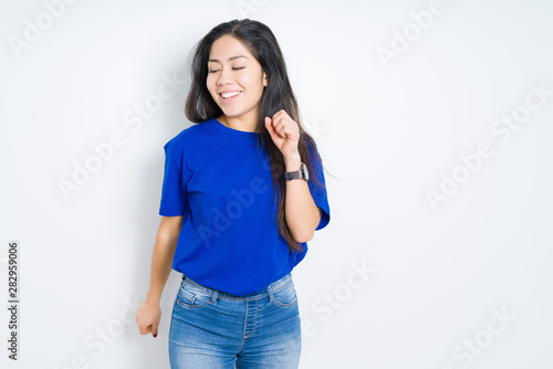 Beautiful brunette woman over isolated background Dancing happy and cheerful, smiling moving casual and confident listening to music © Krakenimages.com