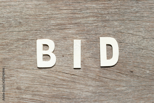 Alphabet letter in word bid on wood background photo