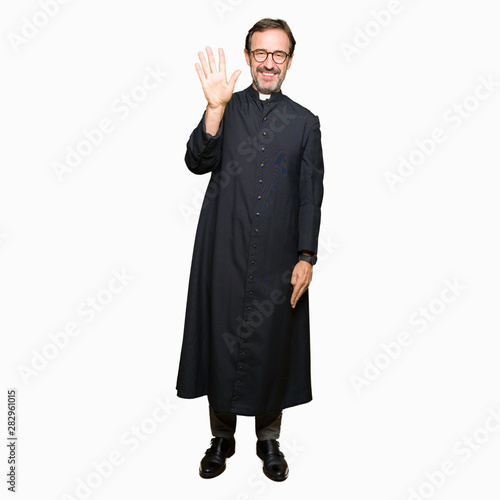 Middle age priest man wearing catholic robe showing and pointing up with fingers number five while smiling confident and happy.