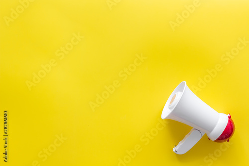 Announcement with megaphone on yellow background top view mockup