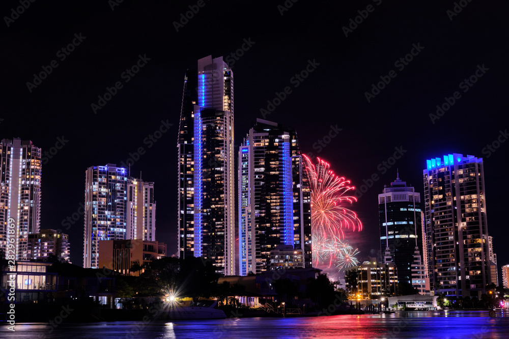 Fototapeta premium Fireworks exploding behind two buildings Gold Coast, Australia
