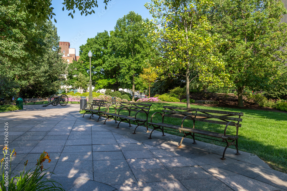 Obraz premium Park Bench in a Park with Pavers and Grass