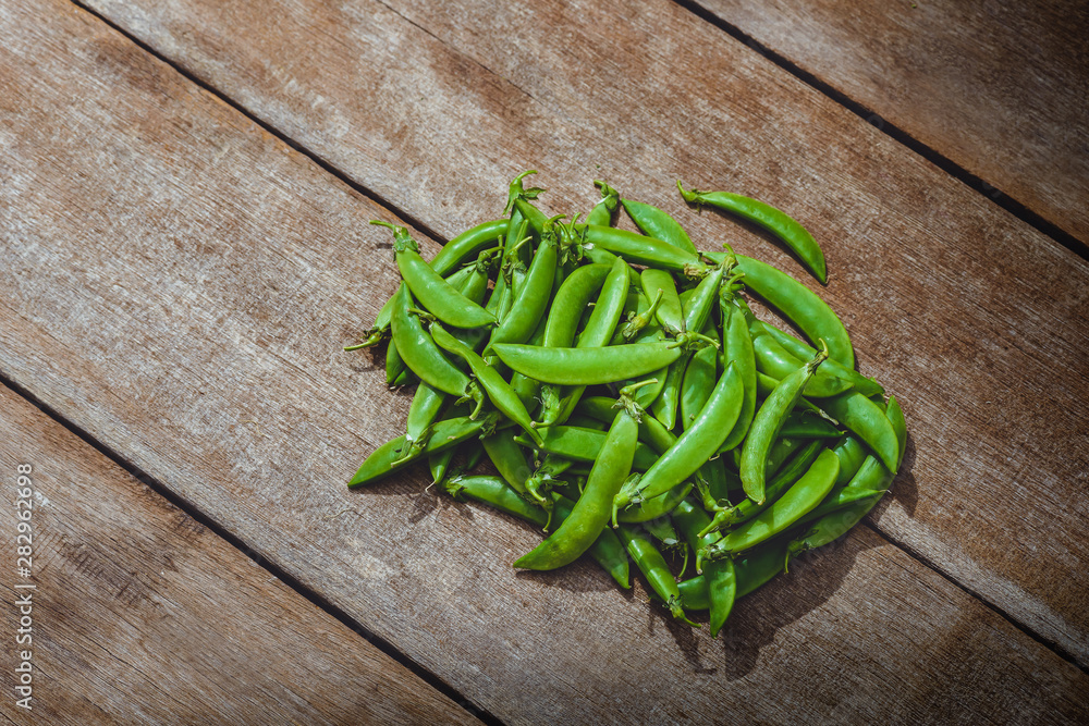 Fresh green peas or beans on wooden table Fresh green peas or beans on wooden table