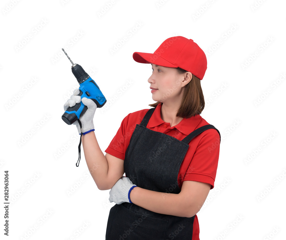 Portrait of young woman worker smiling in red uniform with apron, glove hand holding electric drill isolated on white backround Portrait of young woman worker smiling in red uniform with apron, glove hand holding electric drill isolated on white backround